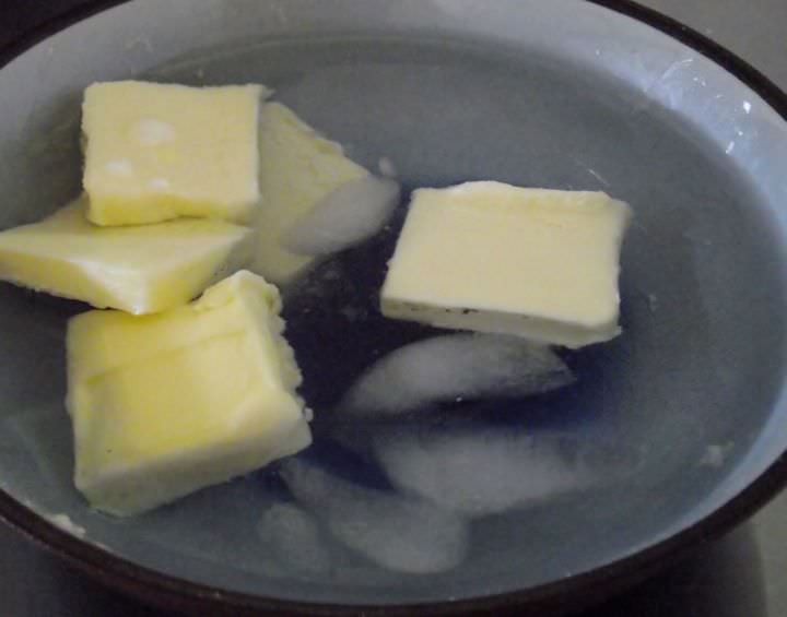 Butter squares floating in ice water.