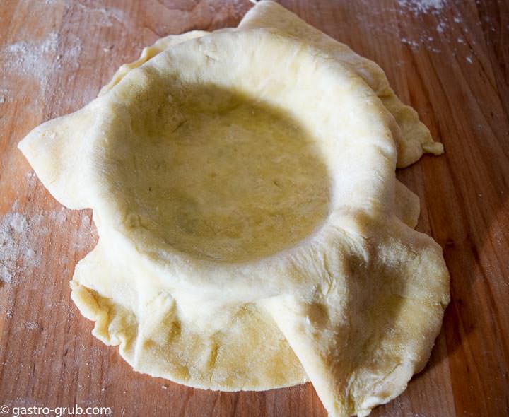 Lining pie pans with pastry.