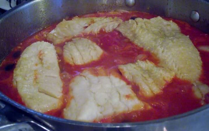 Salt cod braising in a tomato sauce.