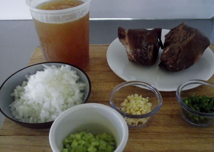 Ingredients for baked beans: chicken stock, smoked ham hocks, onions, garlic, celery, and jalapeno chilies.