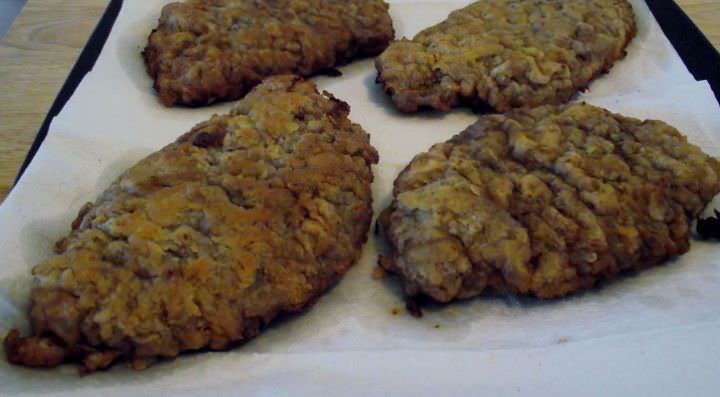 Chicken fried steak resting on a paper lined plate.