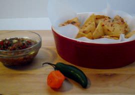 Tortilla chips, salsa, and chili peppers.