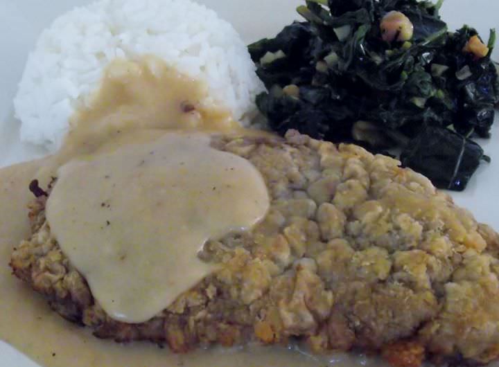 Chicken fried steak, white rice, fried greens and chicken gravy.