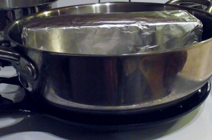 Here, I set a large saute pan on top of the breasts and weighted it down with a brick wrapped in foil.