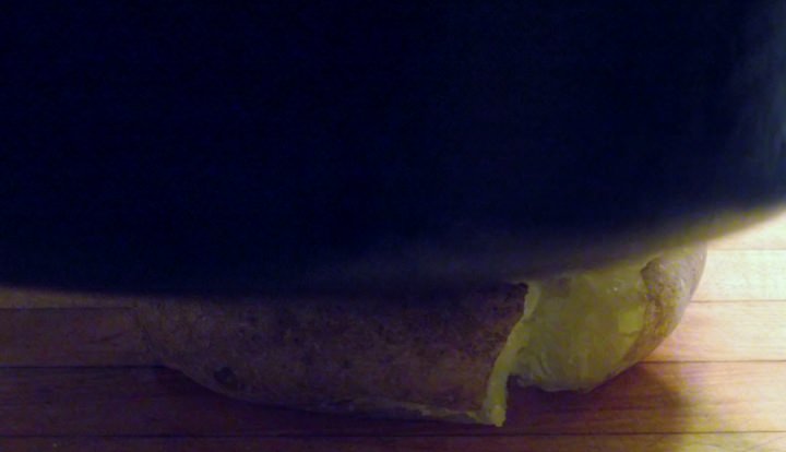 Smashing a potato with a cast iron skillet.