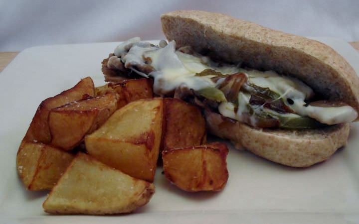 Philly cheese steak and fried potato wedges.