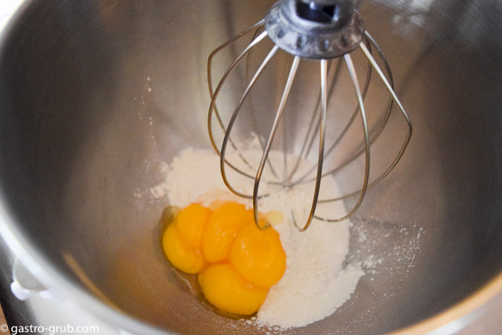 Combine the yolks, half the sugar, and the flour together into a mixer bowl.