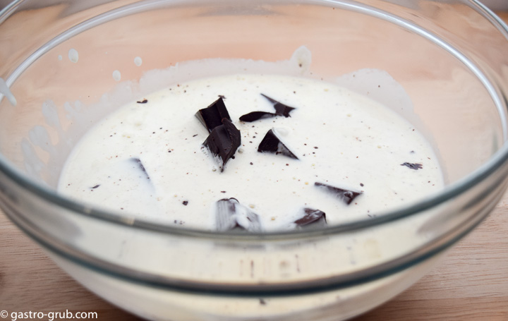 Place the chocolate into a mixing bowl. In a medium saucepan, bring the cream to a simmer. Pour the hot cream over the chocolate. Allow to stand for 1 minute.