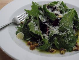 A green salad with shaved parmigiano.