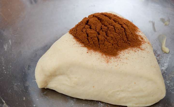 Adding cinnamon to the small piece of dough.
