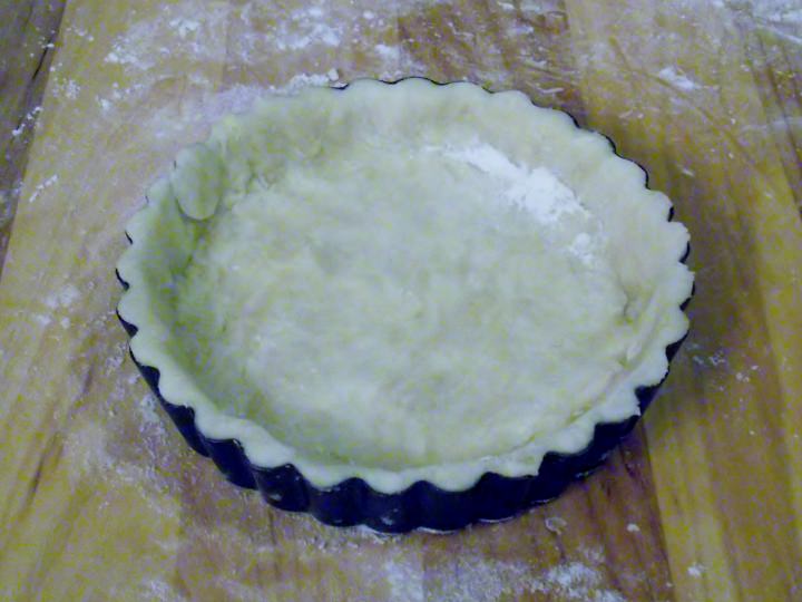 Pastry crust lining an individual tart pan.