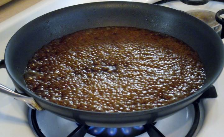 Pork braising liquid boiling in a pot, for pan sauce.