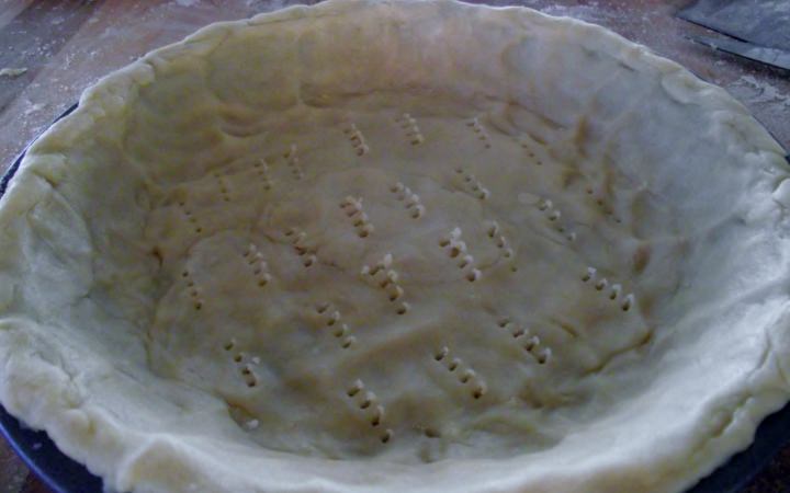 Unbaked pie crust lining a pie plate.