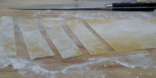 Cutting the rolled pasta into papperdelle.