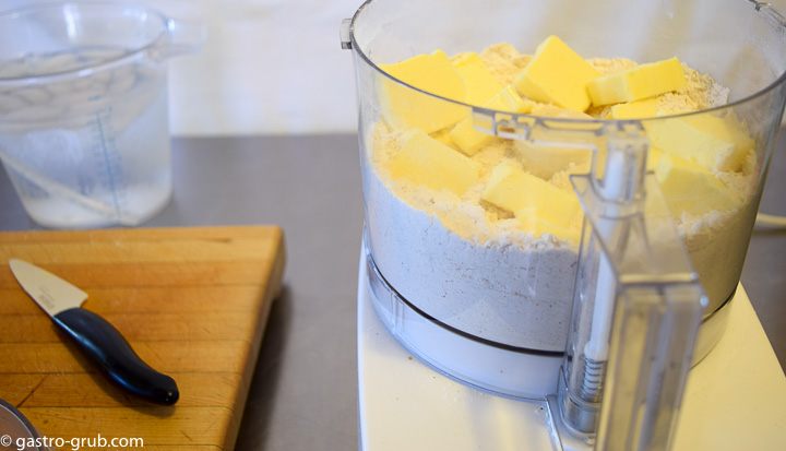 Adding butter to flour mixture in the food processor.