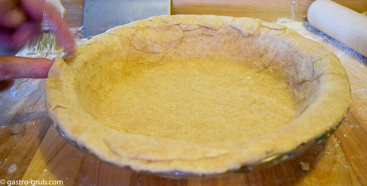 Pie dough being pressed and fitted to the pie plate.