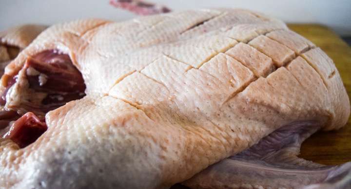 Scoring the skin on the duck.