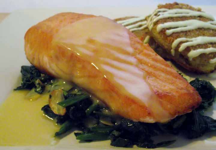 Seared Salmon with beurre blanc on top of sauteed greens and potato croquettes with green onion aioli.
