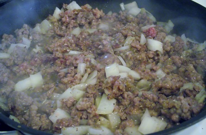 Cooking ground beef and onions in a skillet.