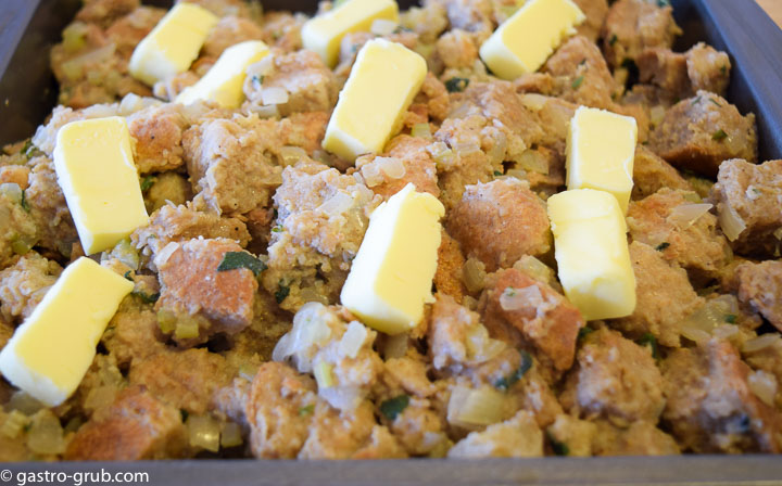 Bread dressing with butter knobs, ready for the oven.