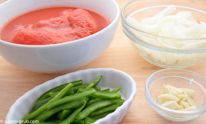 Ingredients for tomato puree: whole peeled tomatoes, onions, garlic, and jalapeno peppers.