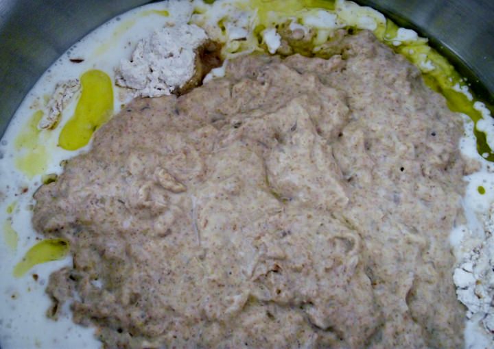 Adding the sponge, olive oil, and buttermilk to the flour mixture.