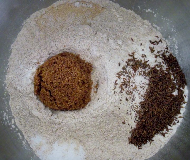 The flours, salt, sugar, caraway seeds, and yeast in the bowl of a stand mixer.