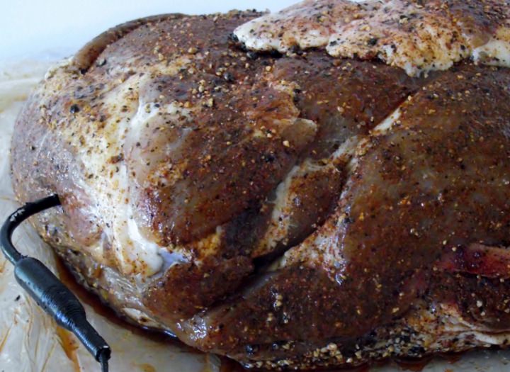 Pork shoulder showing the insertion of the thermometer probe.