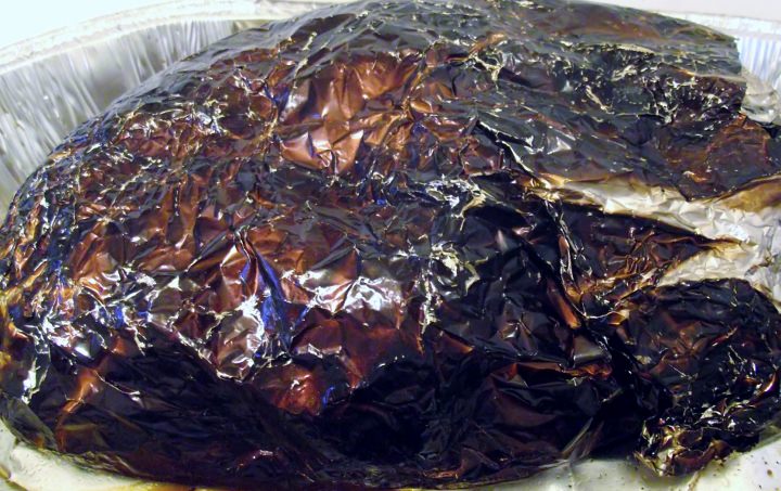 Pork shoulder wrapped in foil, after smoking.