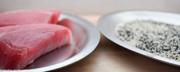 Tuna steaks and sesame seeds on separate platters.