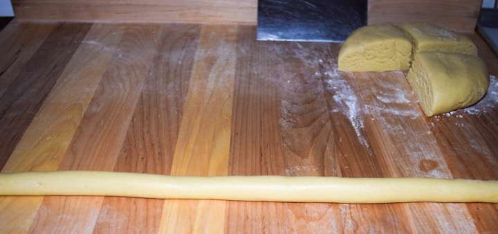 Working one piece at a time roll the dough into long thin ropes, about half an inch thick.