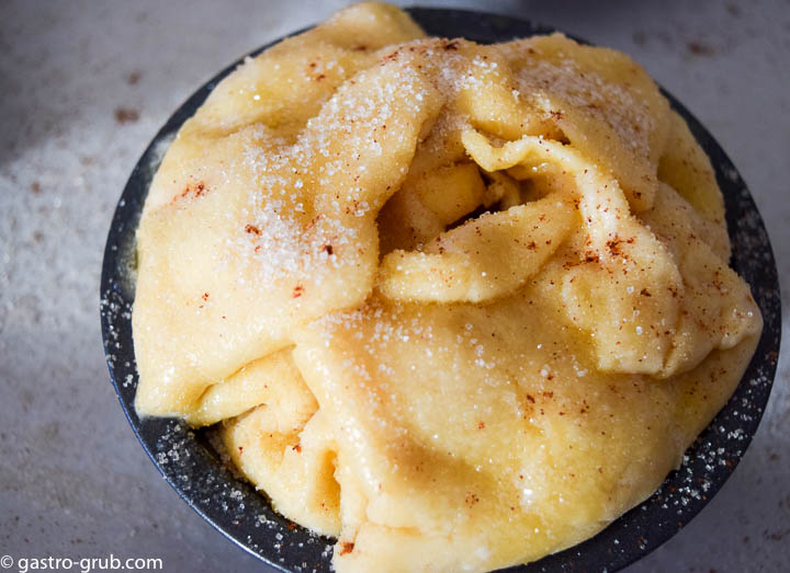 Topping the pies with butter and sugar.