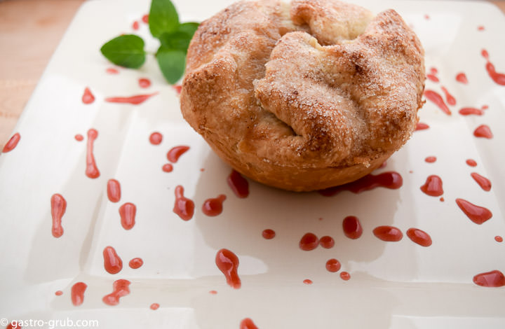 Apple pie with strawberry coulis, on a plate.