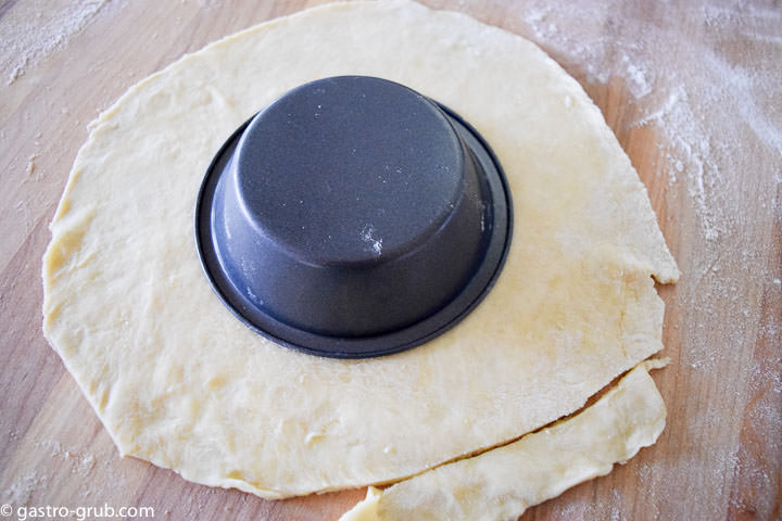 Rolling out and measuring pastry for individual apple pies.