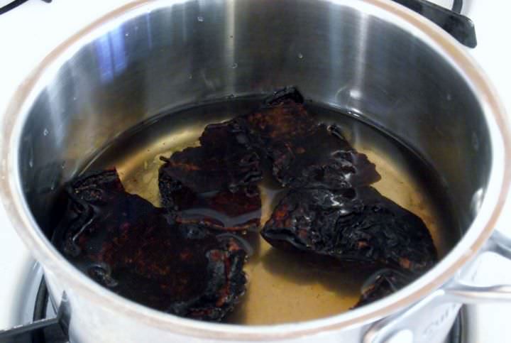 Toasted pasilla chilies and water in a pot