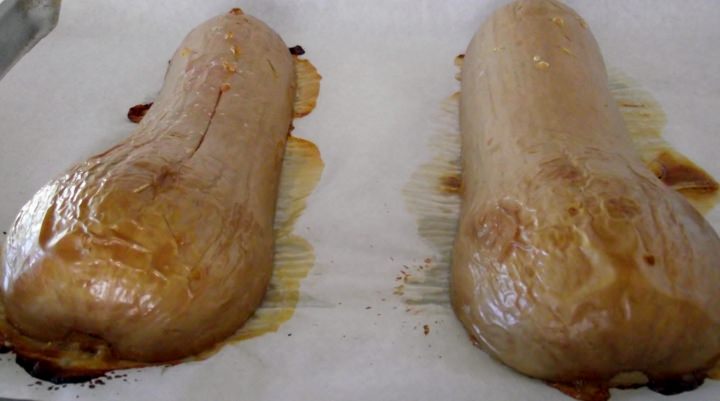 Butternut squash cooling on a roasting pan after being removed from the oven.