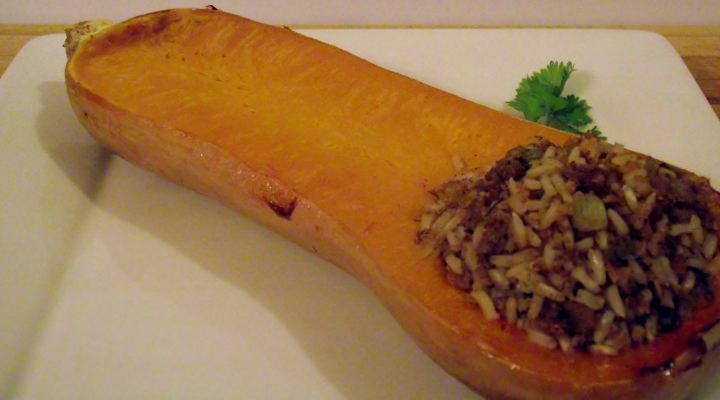 Sausage and rice stuffed butternut squash on a plate.