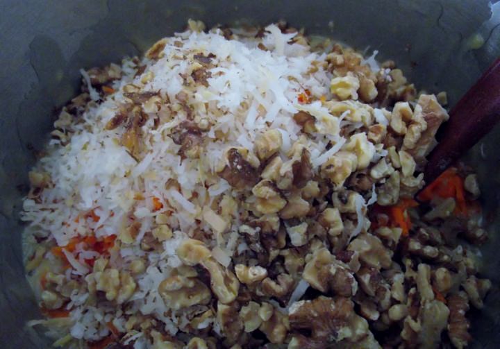 Adding the carrots, walnuts, and coconut to the cake batter.