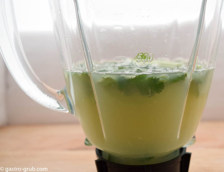 Lime juice and ceviche ingredients in a blender jar.