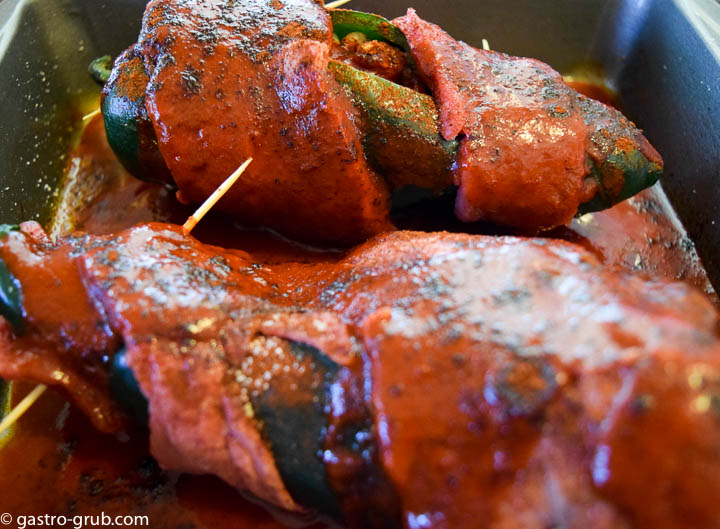 Chile rellenos in a casserole with New Mexican chili sauce.