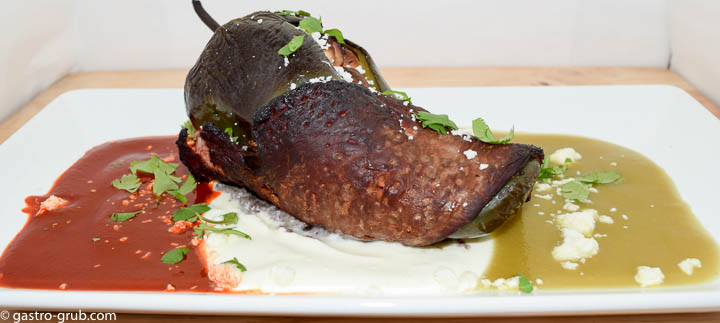 Chile relleno wrapped with flank steak and served with chili sauce, crema, and tomatillo sauce.