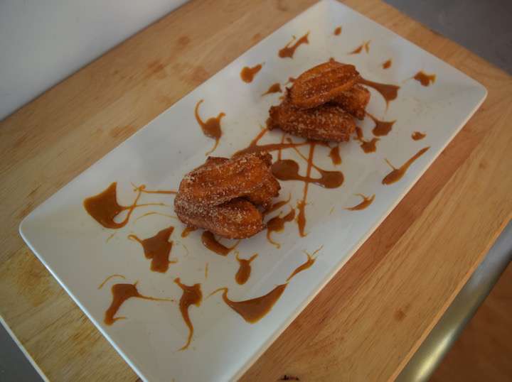 Churros on a plate with dulce de leche.