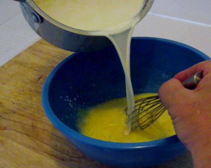 Tempering egg yolk mixture with the cream mixture.