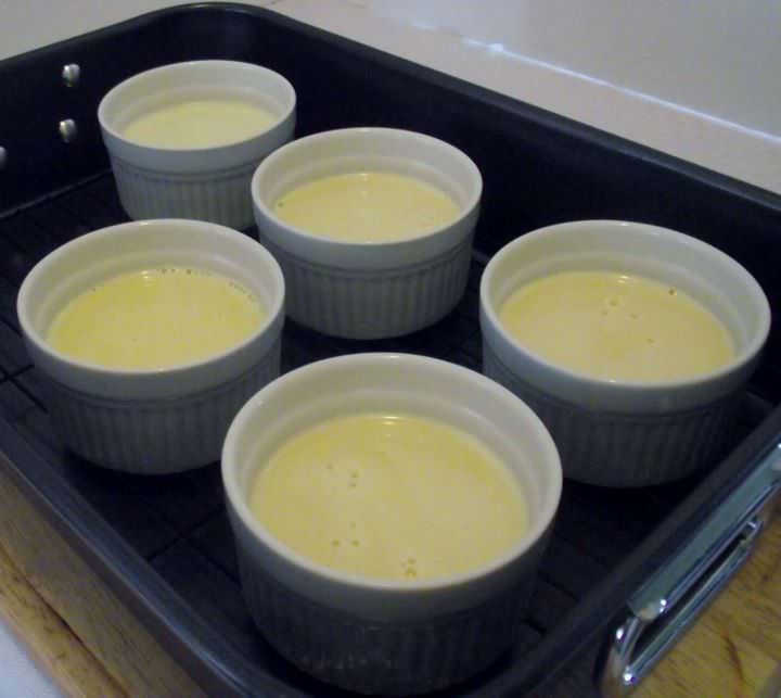 Creme brulee in remekins in a roasting pan. Ready for the oven.