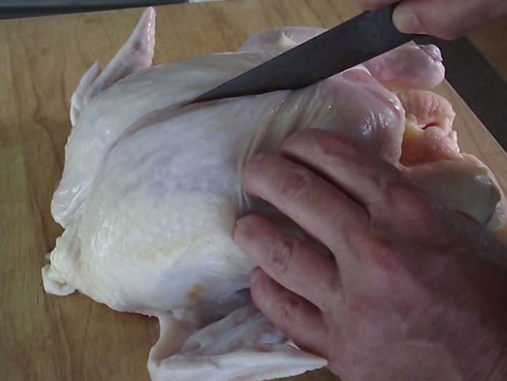 Removing the breast from a chicken.