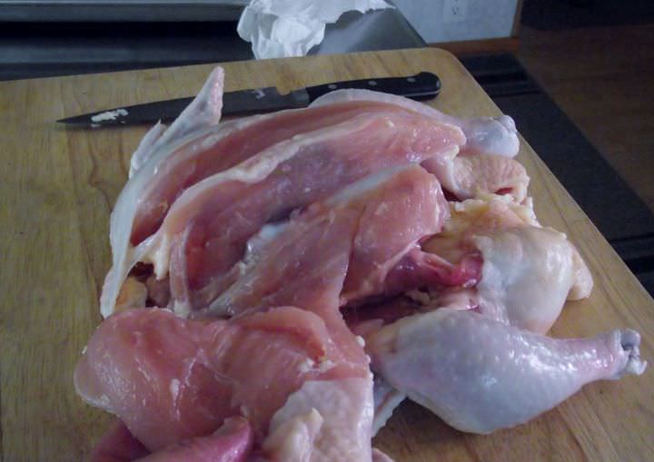 Removing the breasts from a whole chicken.