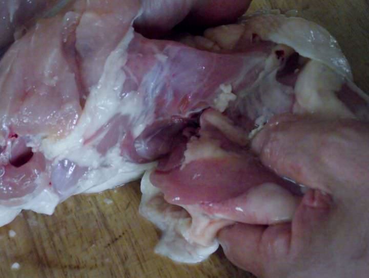 Beginning to remove the thighs and legs from the chicken.