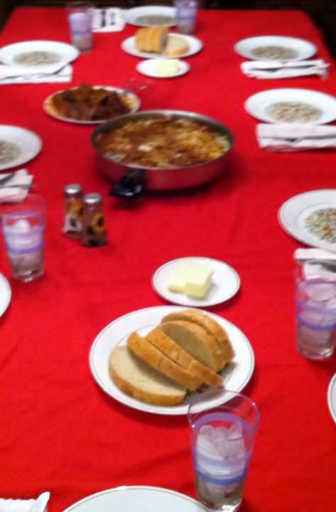 Table set for Sunday dinner with ravioli and braised meat.