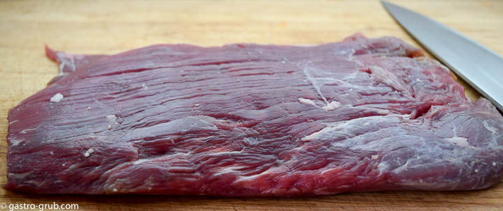 Flank steak on a cutting board.