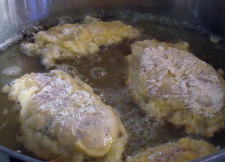 Chicken breasts shallow frying in a saute pan.